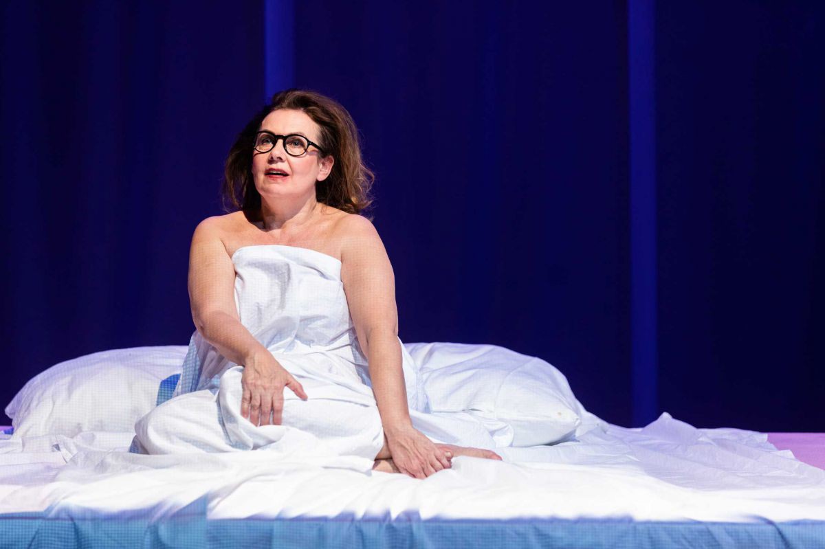 Petra Strasser mit Brille in Bett, Reigen, TAG Theater
