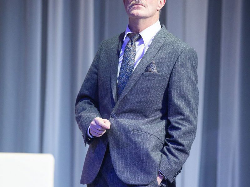 Jens Claßen mit Anzug und Brille, Medea, TAG Theater Jens Claßen mit Anzug und Brille, Medea, TAG Theater