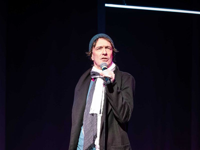 Jens Claßen sing mit Mikro auf Bühne, Reigen, TAG Theater Jens Claßen sing mit Mikro auf Bühne, Reigen, TAG Theater